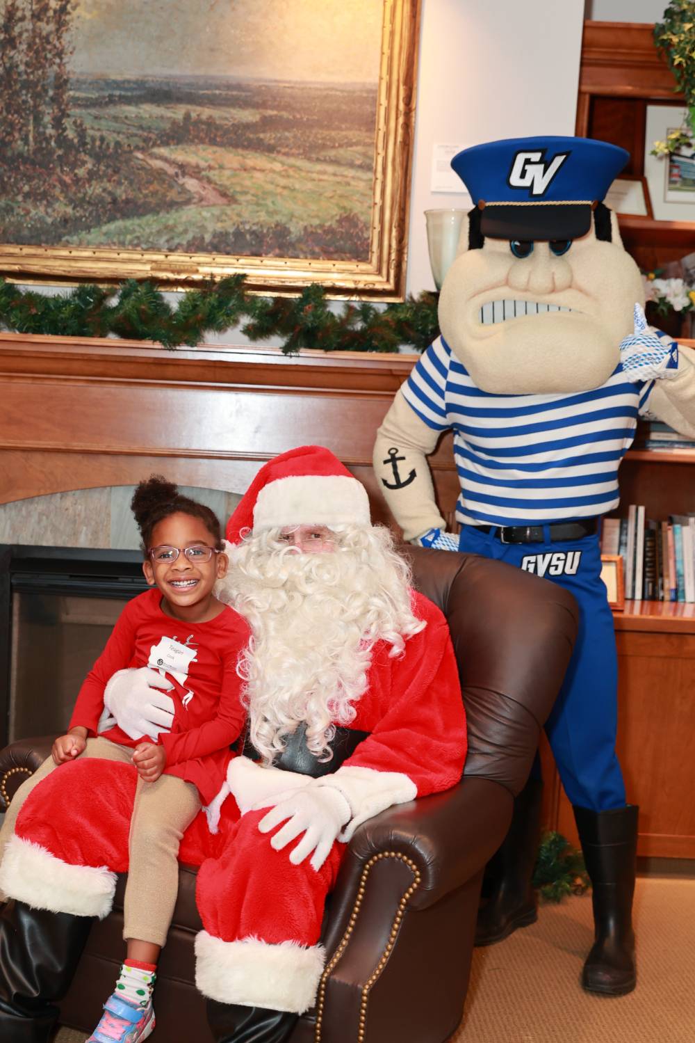 A girl sitting with Santa & Louie.